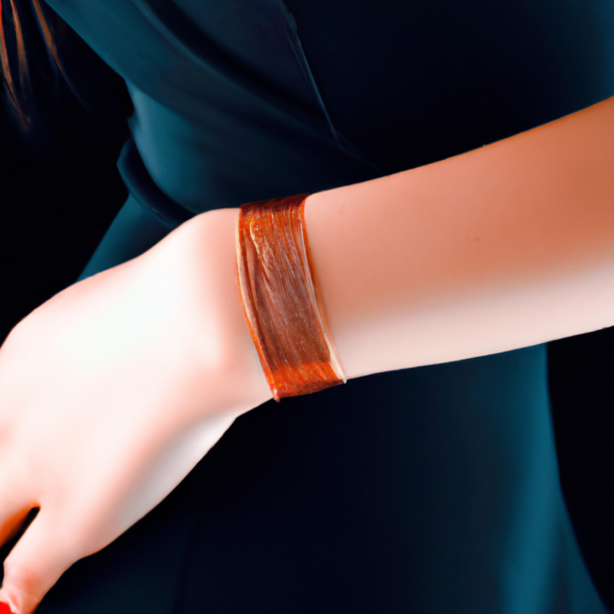 A close-up of a hand wearing a simple brown bracelet on a wrist.